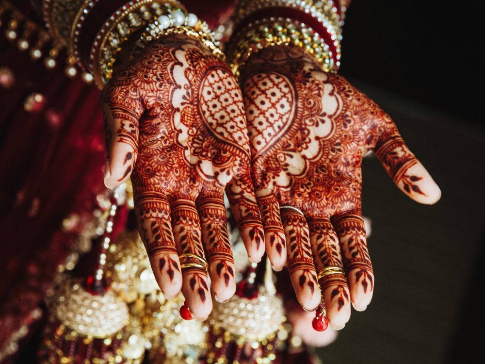 Mehndi wedding ornament on the hands drawn by henna
